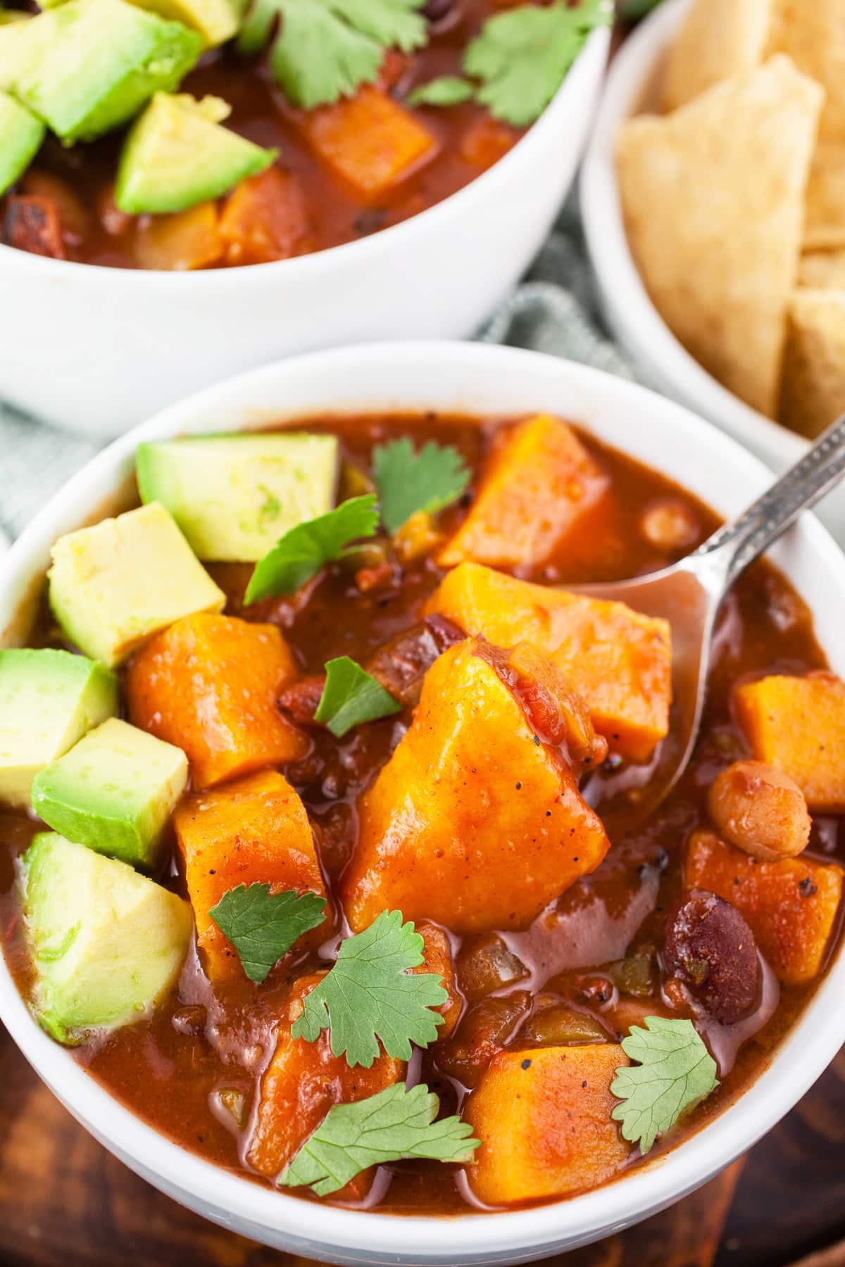 Sweet potato chili in white bowl with spoon.