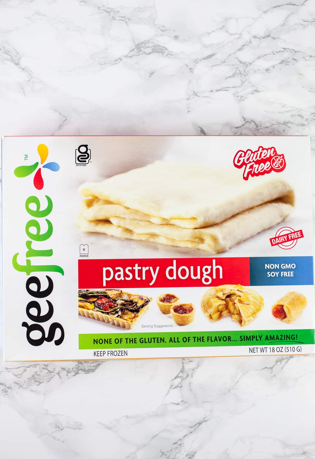 Package of gluten free puff pastry dough on white surface.