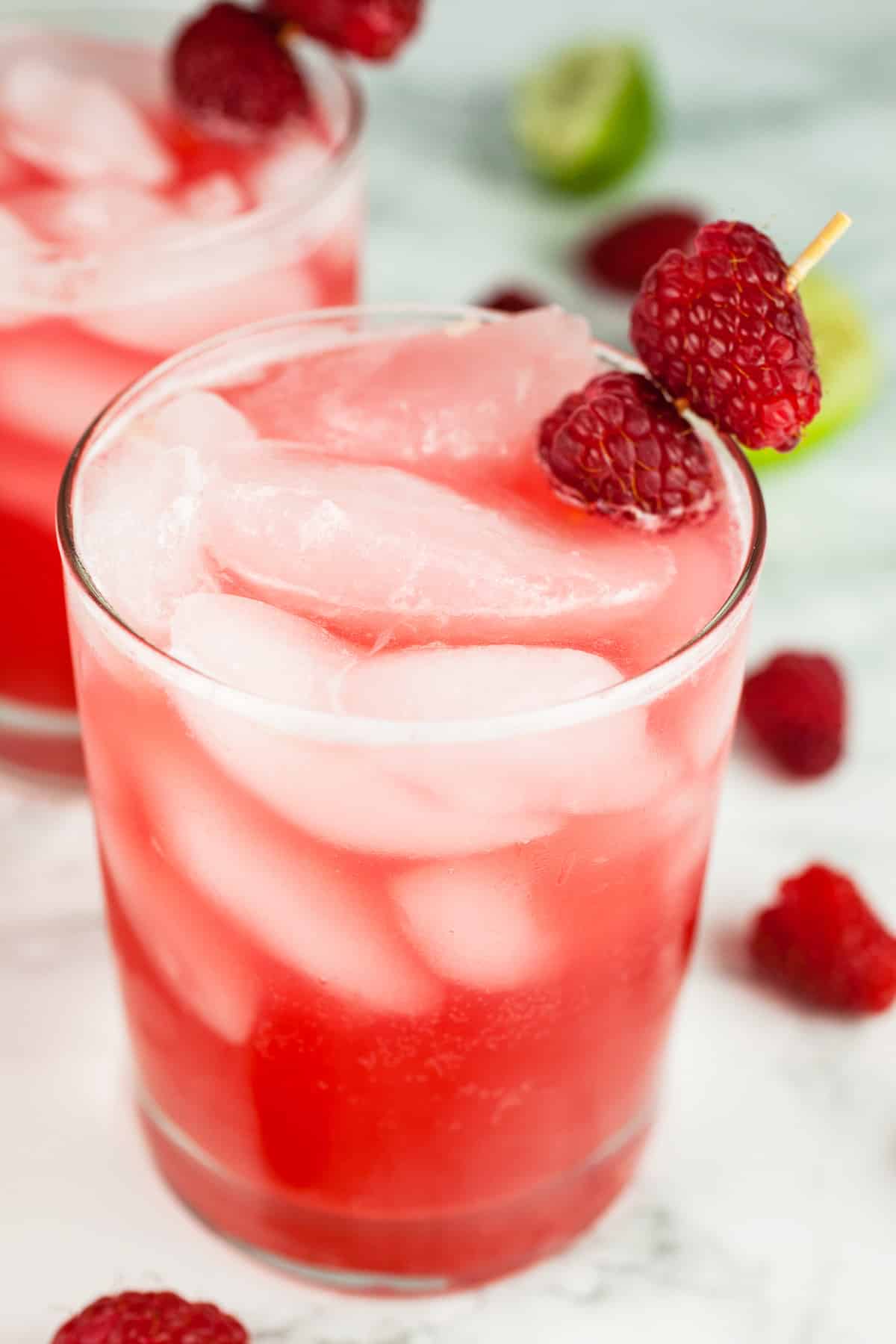 Raspberry mule cocktails in glasses garnished with fresh raspberries.