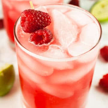 Raspberry mule cocktail in glass with fresh raspberry garnish.
