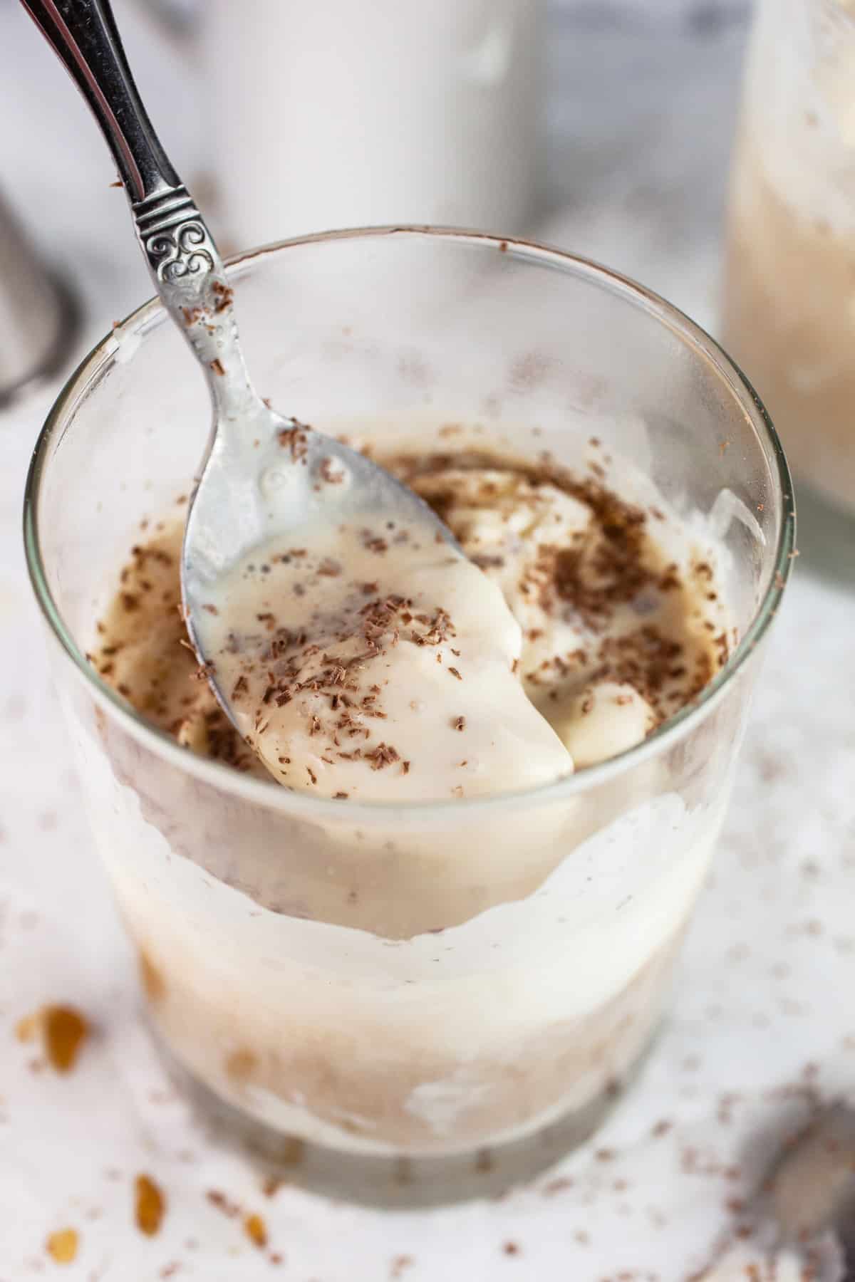 Spoonful of affogato ice cream cocktail in glass.