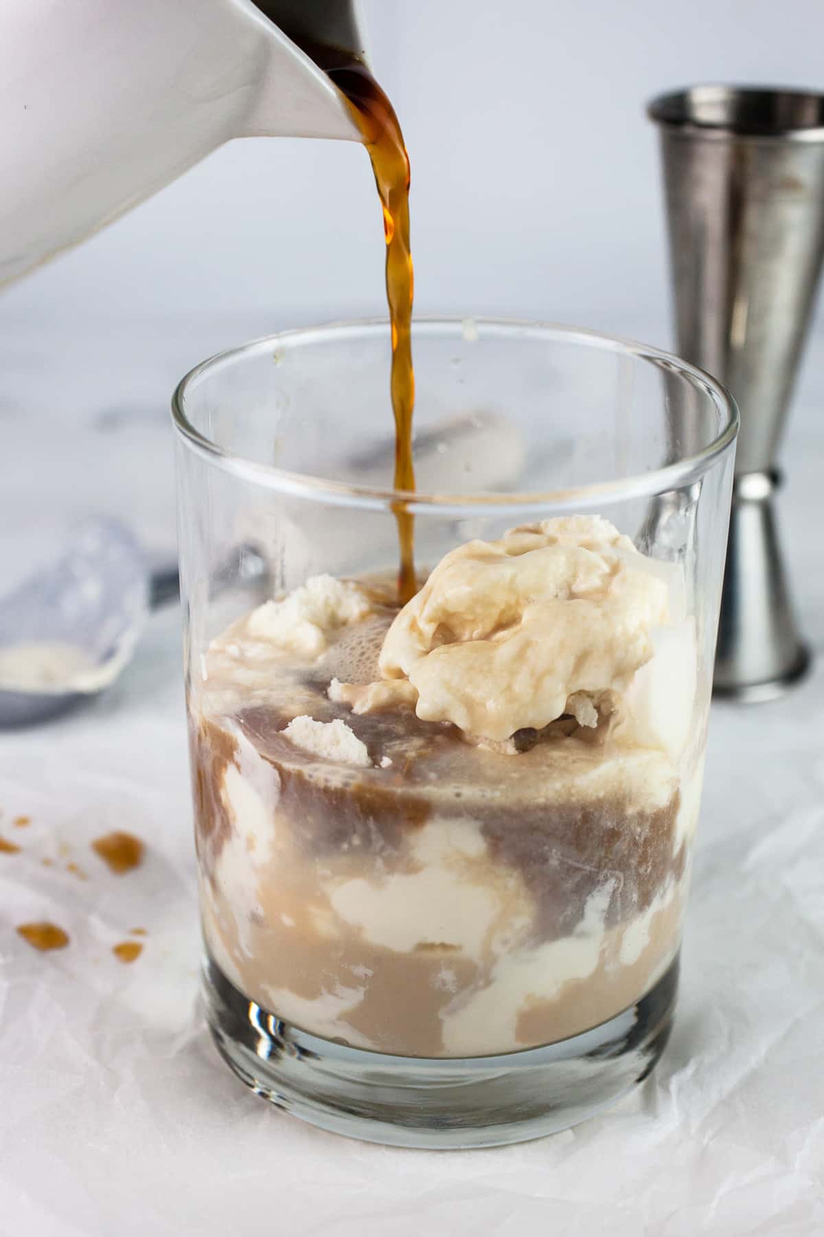 Coffee poured into glass with ice cream, whiskey, and Baileys.