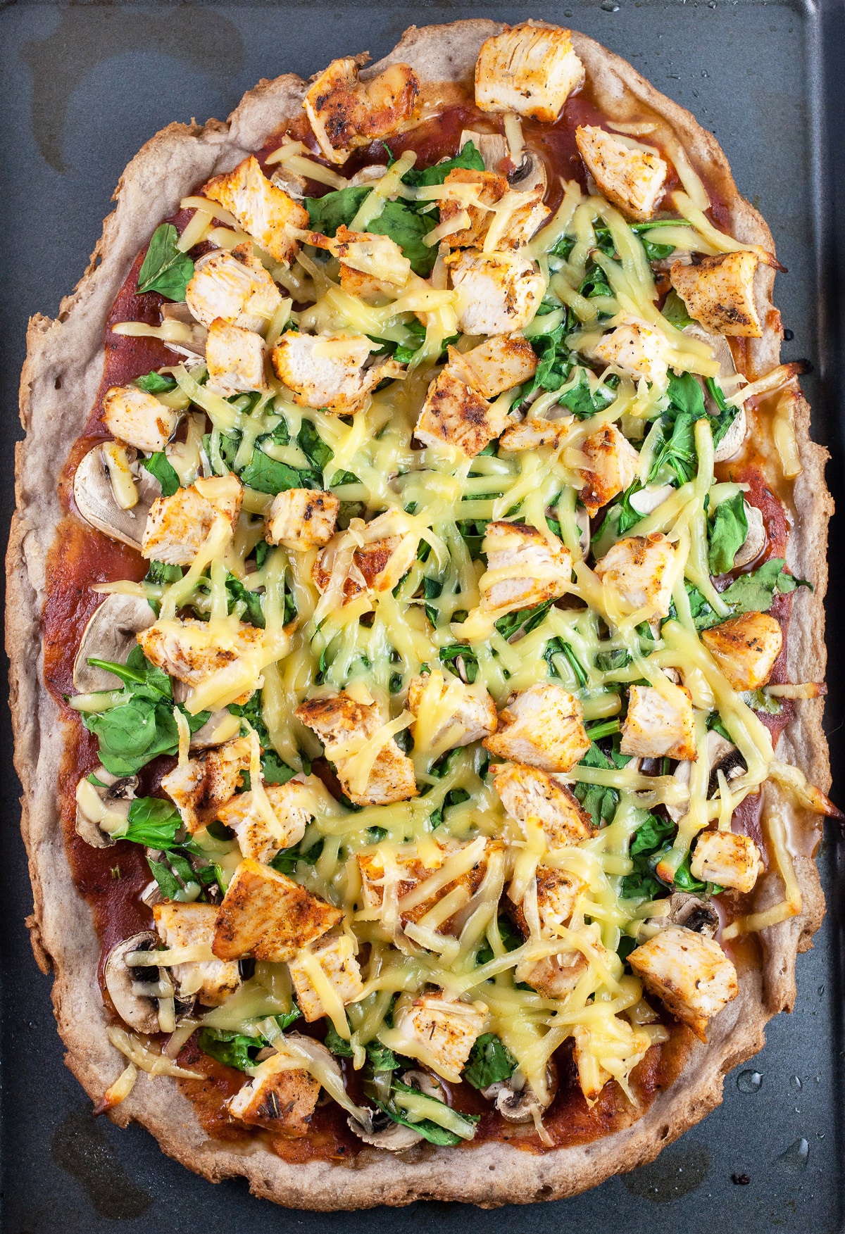 BBQ chicken pizza on baking sheet.