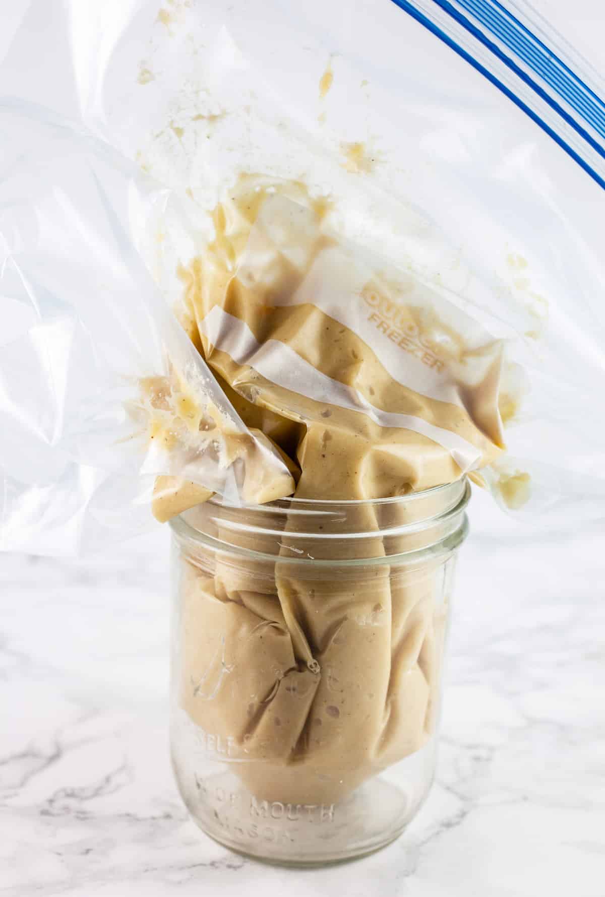 Doughnut batter in plastic freezer bag placed in a Mason jar.