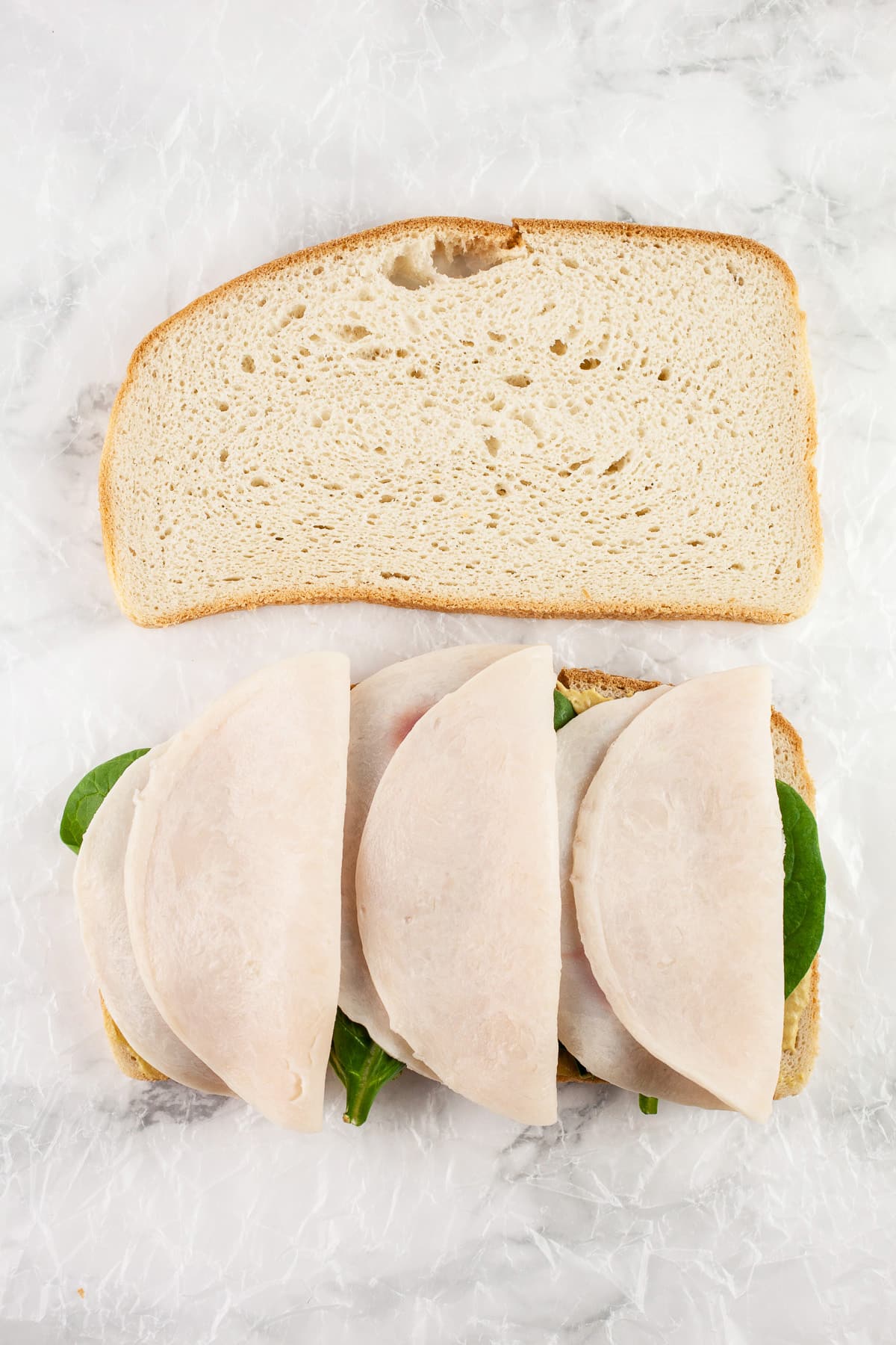 Sliced bread with deli chicken.