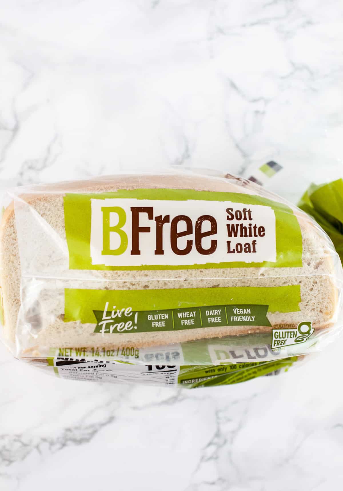 Package of gluten free bread on white surface.