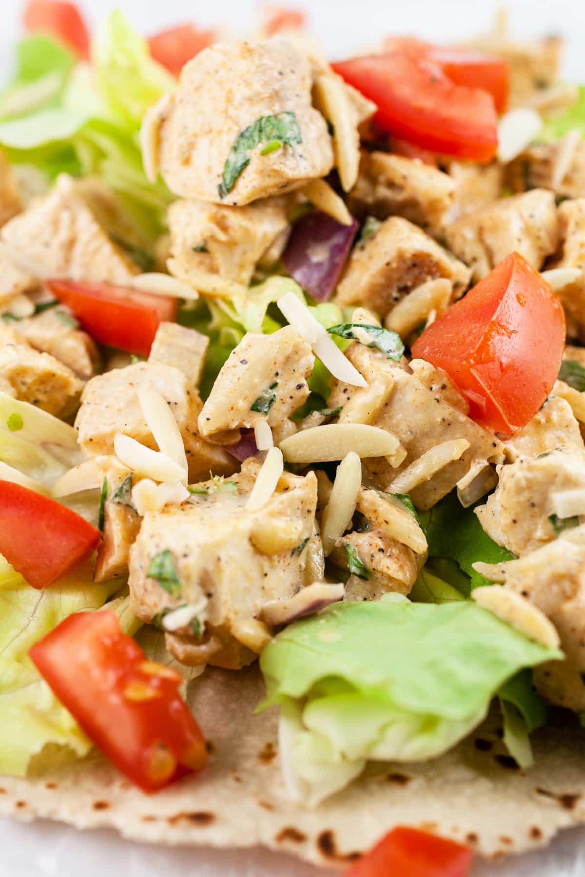 Lemon tarragon chicken salad with slivered almonds, tomatoes, and lettuce on wrap.
