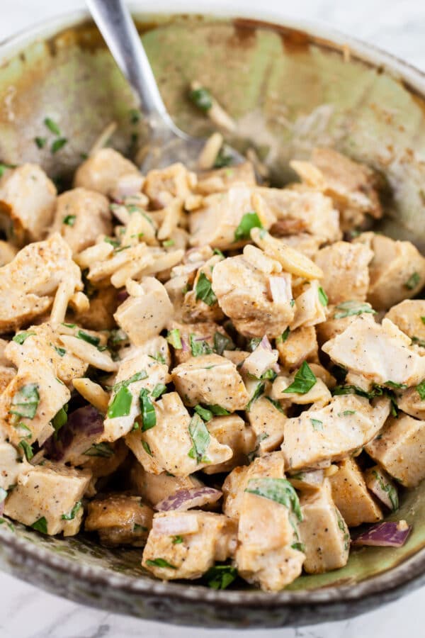 Tarragon chicken salad in ceramic bowl with spoon.