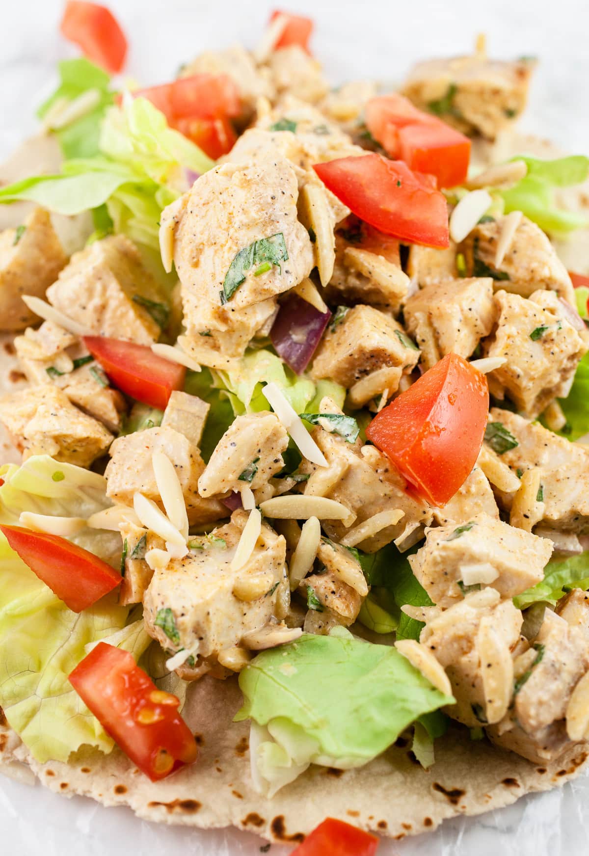 Lemon tarragon chicken salad with diced tomatoes, lettuce, and slivered almonds on a wrap.