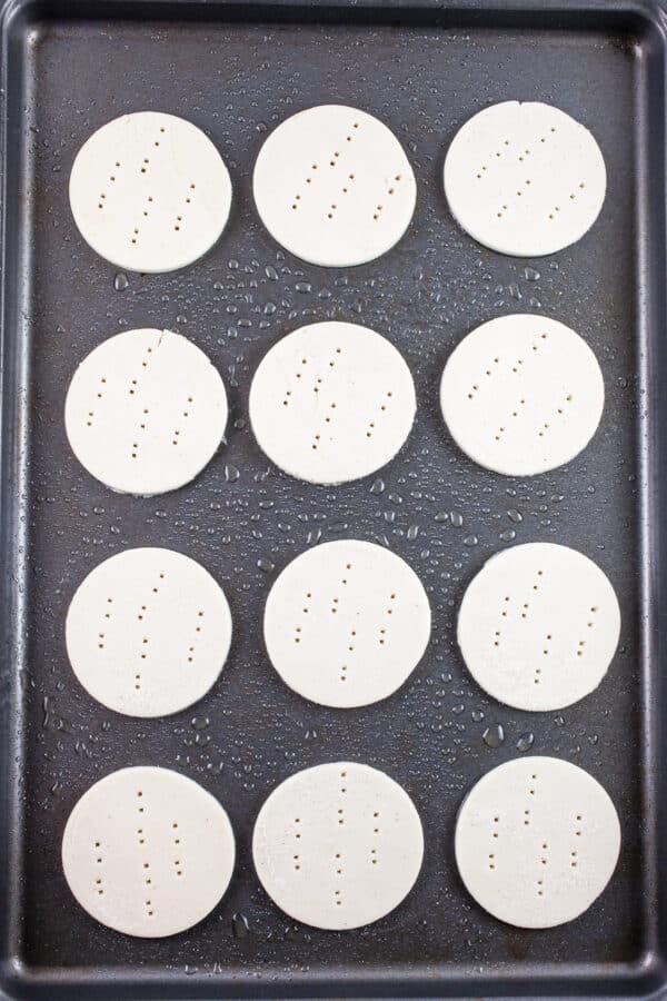 Unbaked puff pastry rounds on baking sheet.