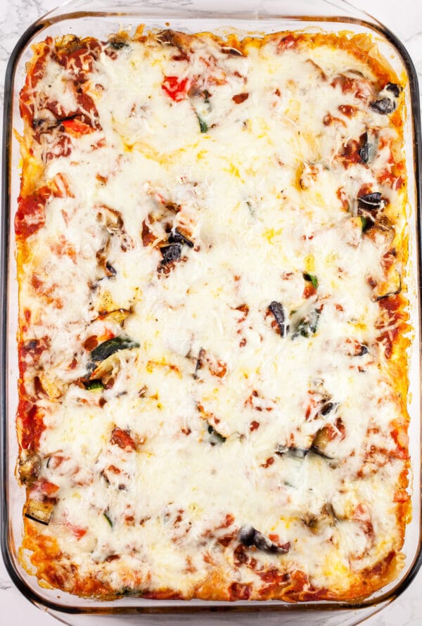 Cooked vegetable lasagna in glass baking dish.