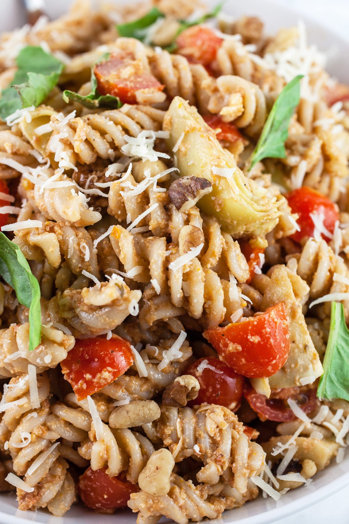 Sundried tomato pesto pasta salad with artichokes, fresh tomatoes, basil, and Parmesan cheese.