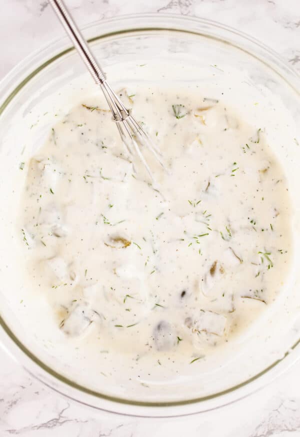 Mayo tartar sauce in glass bowl with whisk.