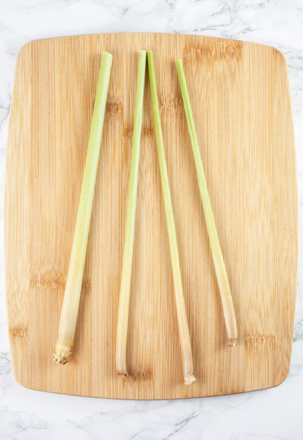 Lemongrass stalks on wooden cutting board.