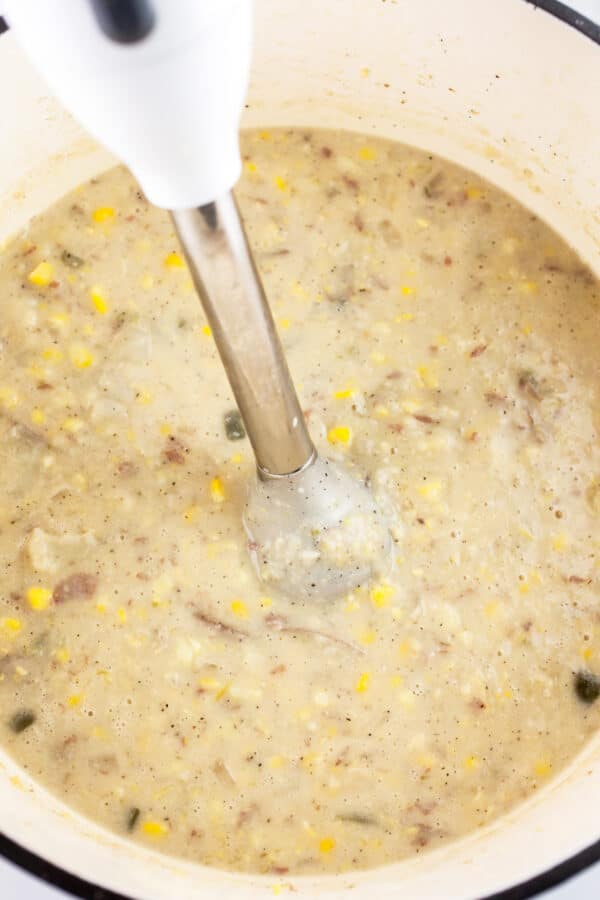 Potato corn chowder in Dutch oven pureed with immersion blender.