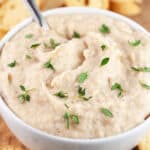 Italian white bean dip in white bowl garnished with fresh thyme.
