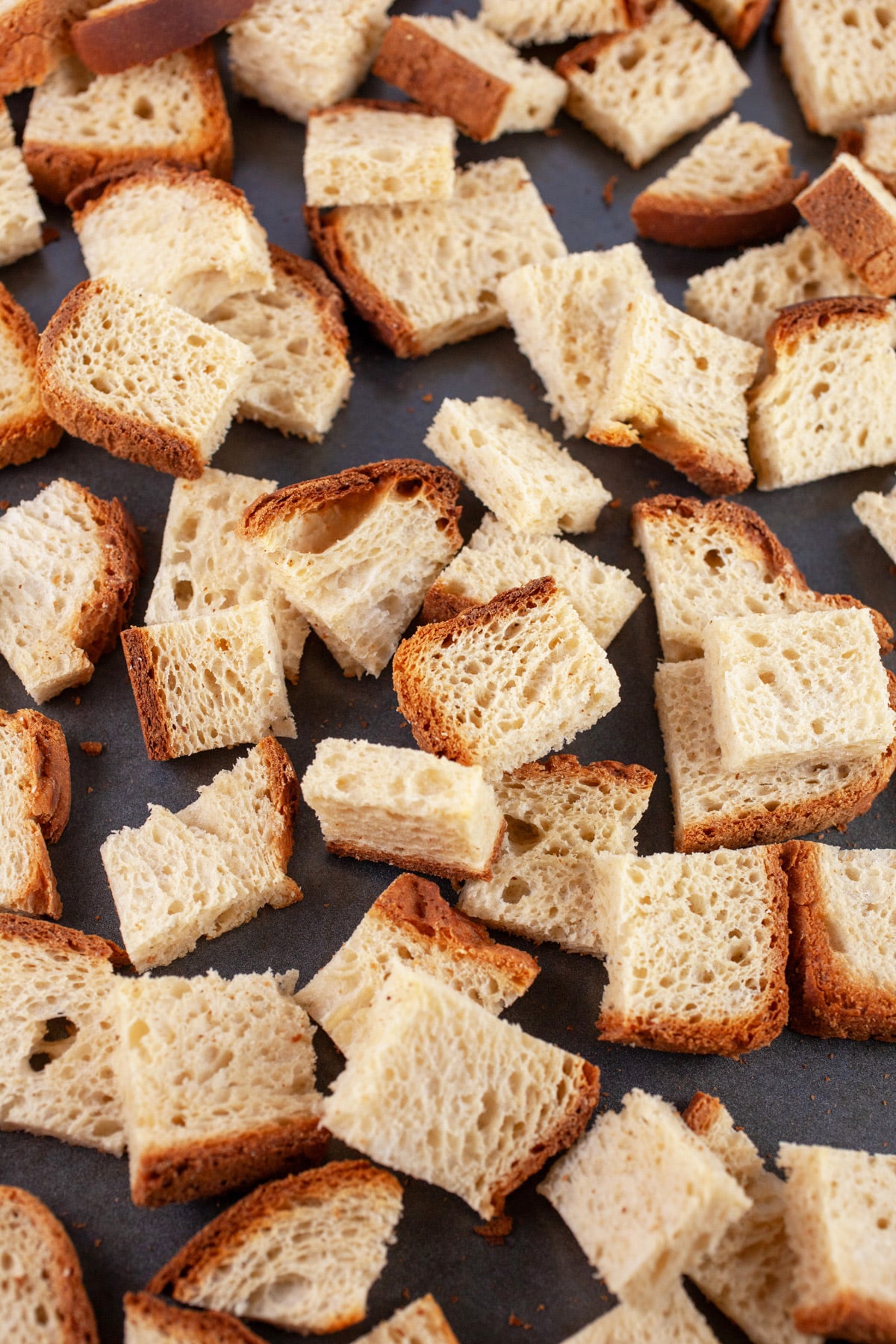 Toasted bread cubes on baking sheet.