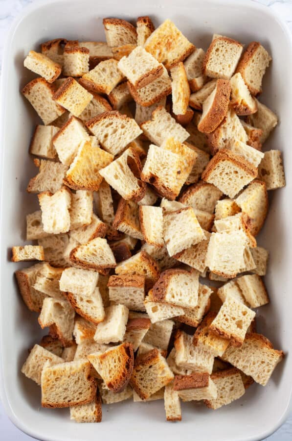 Toasted bread cubes in casserole dish.
