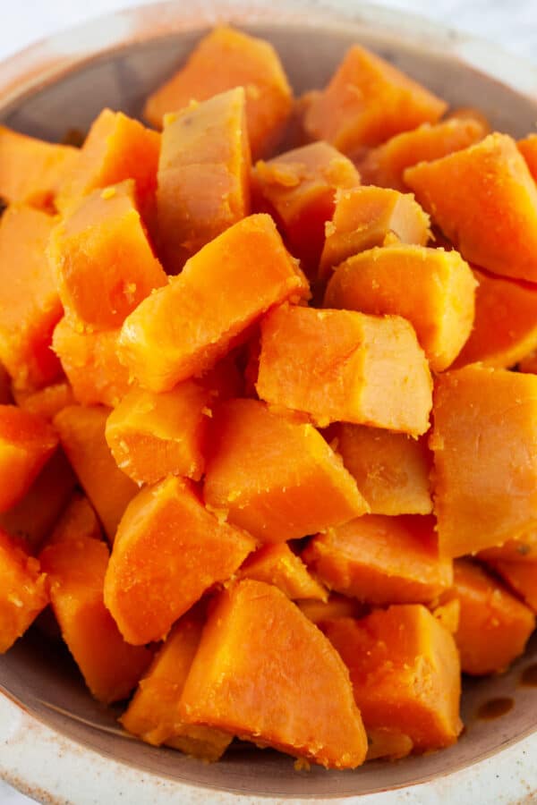 Boiled diced sweet potatoes in ceramic bowl.