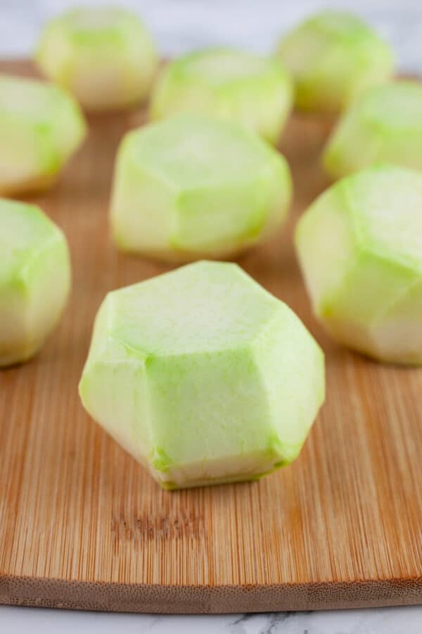 Peeled kohlrabi on wooden cutting board.