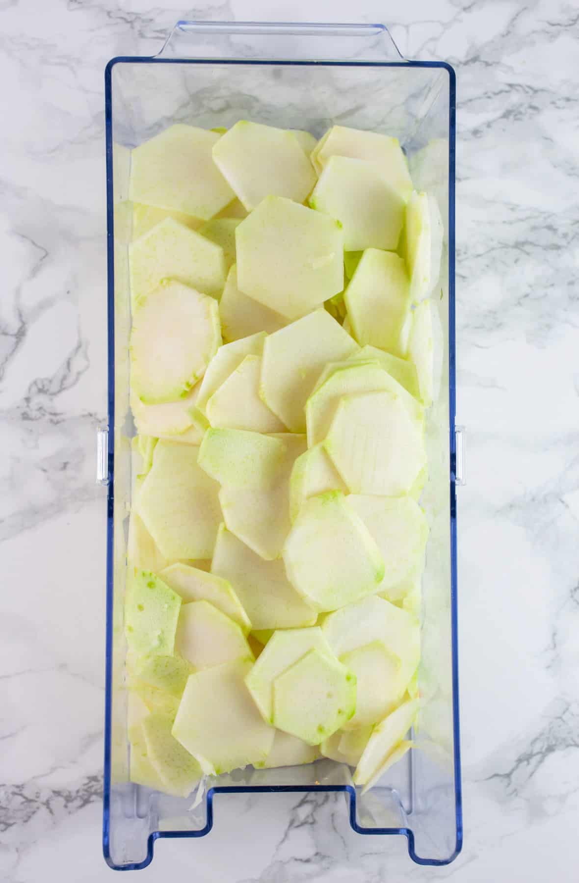 Thinly sliced kohlrabi in plastic container.