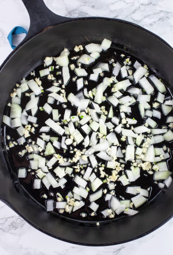 Minced garlic and onions in cast iron skillet.