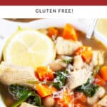 Turkey white bean soup with Parmesan cheese and lemon wheel in white bowl with spoon.