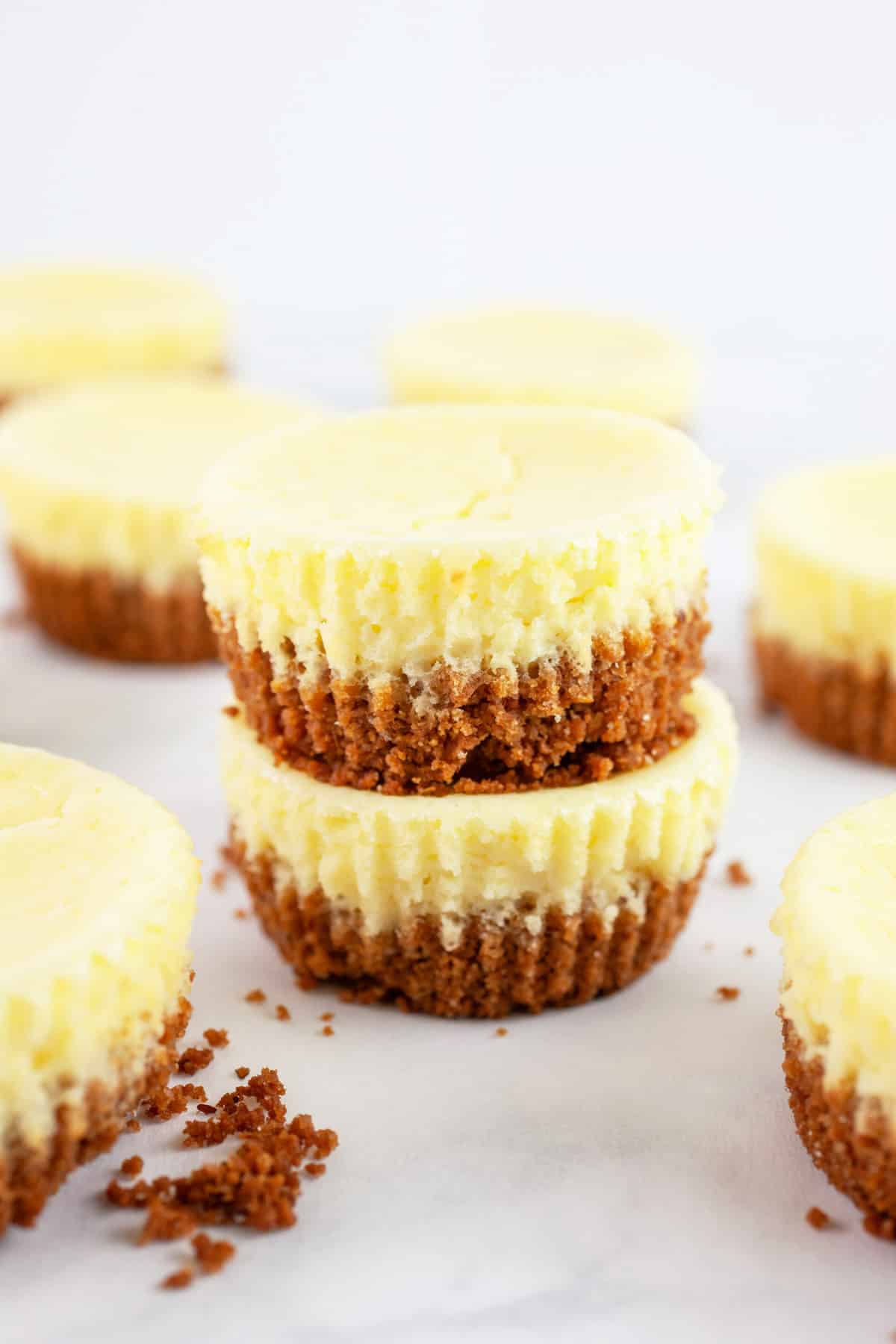 Cheesecake cups stacked on white surface.