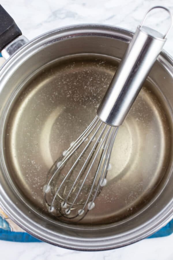 Simple syrup in sauce pan with whisk.