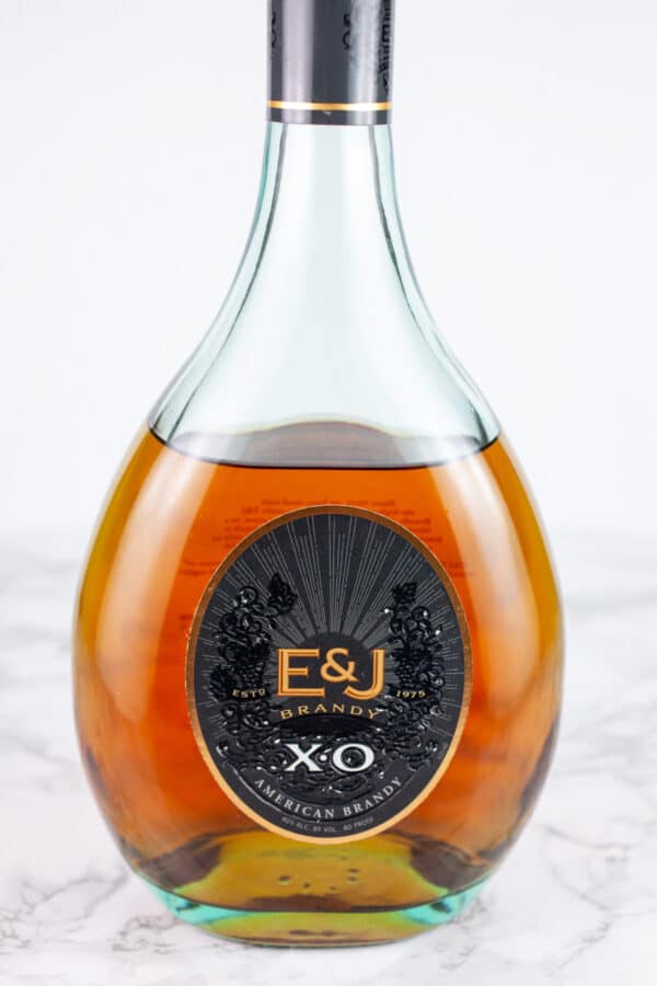 Bottle of brandy on white surface.