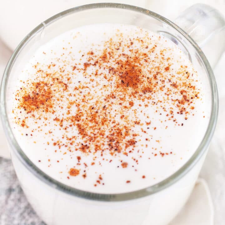 Tom and Jerry cocktail in glass coffee mug garnished with nutmeg.