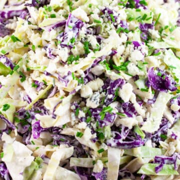 Blue cheese coleslaw with red and green cabbage garnished with minced chives.