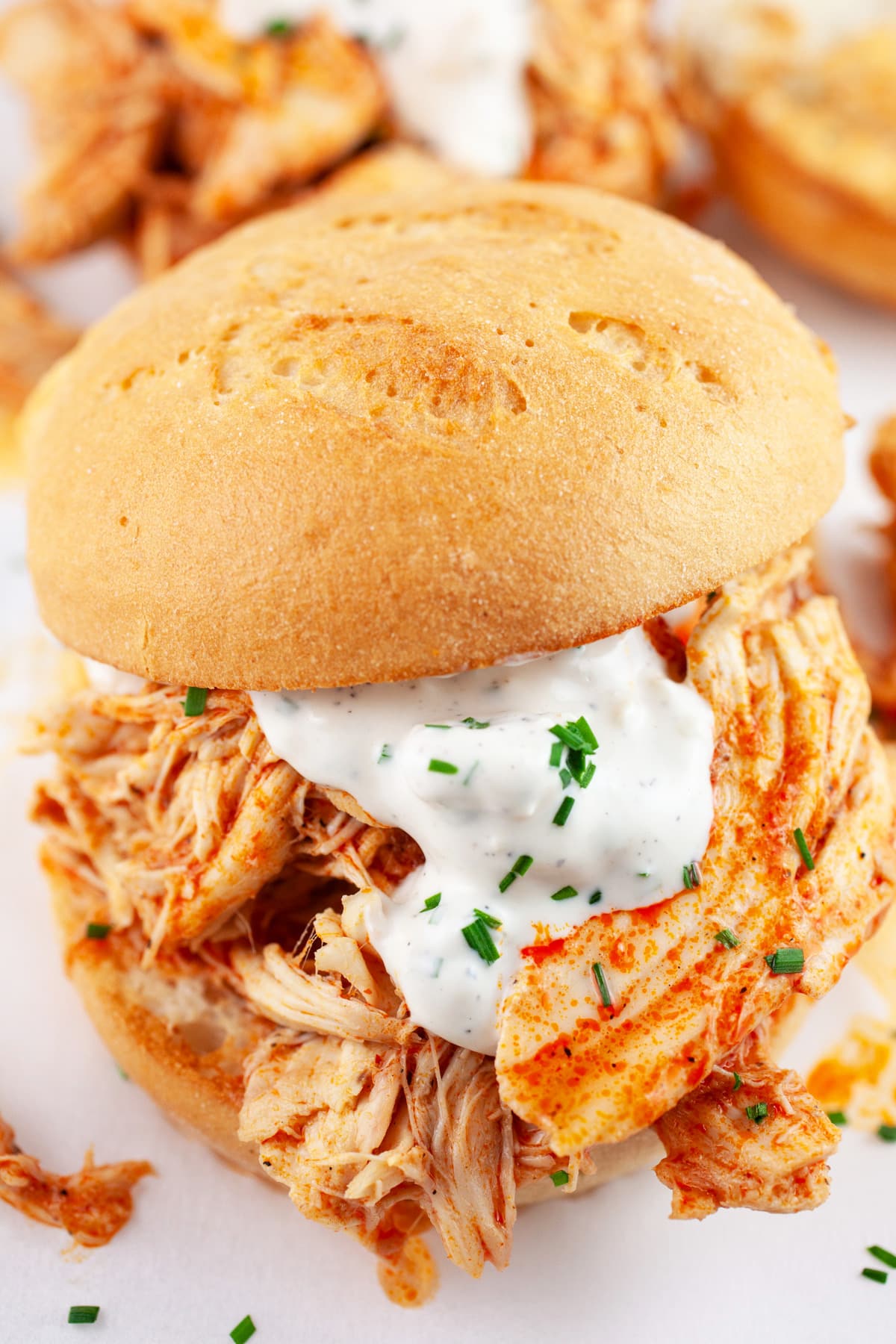 Shredded buffalo chicken on toasted buns with blue cheese sauce.