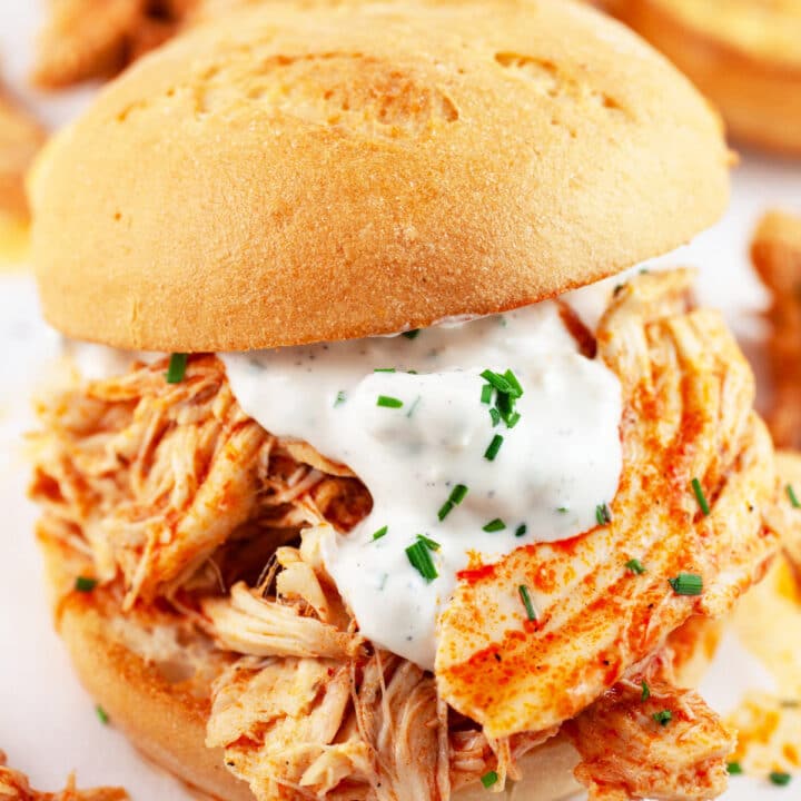 Crockpot shredded buffalo chicken sandwich on bun with blue cheese sauce.