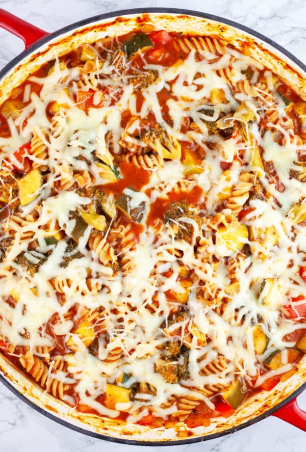 Veggie pasta with melted mozzarella cheese in skillet.