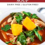 Chicken kale sweet potato soup in white bowl garnished with fresh parsley.