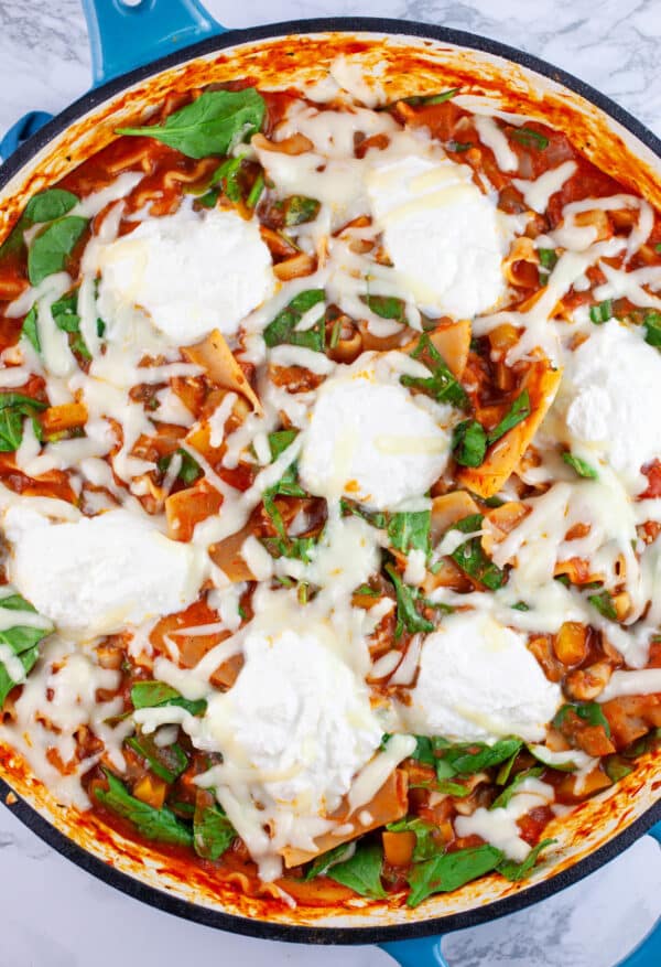 Cooked vegetable lasagna in skillet.