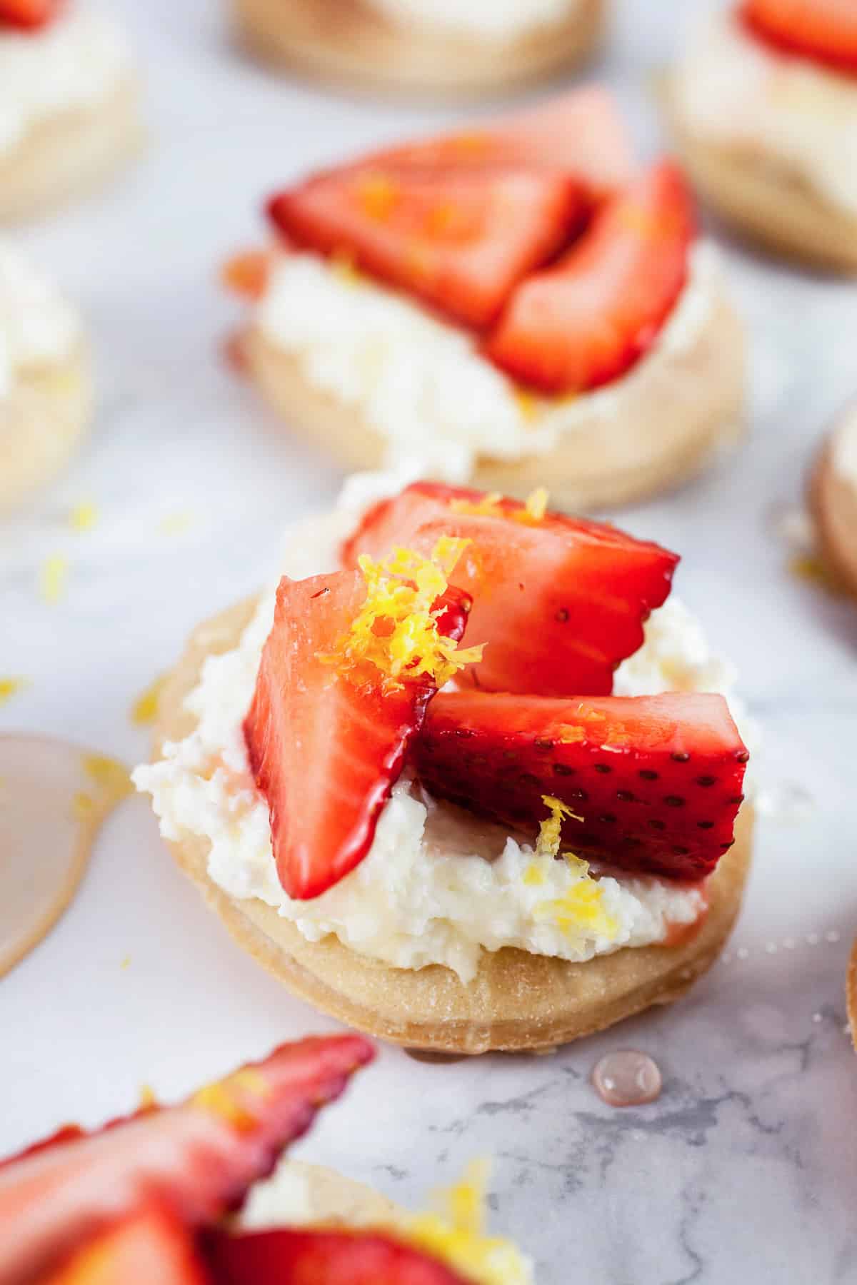 These Honeyed Strawberry and Mascarpone Tartlets make the perfect quick dessert! They're made with light and airy Puff Pastry and topped with a smooth mascarpone cream and fresh strawberries drizzled with honey. Lemon zest balances out the sweetness. These tartlets are fresh and light but decadent at the same time! #ad #puffpastry #inspiredbypuff Strawberry mascarpone tartlets with honey and lemon zest.