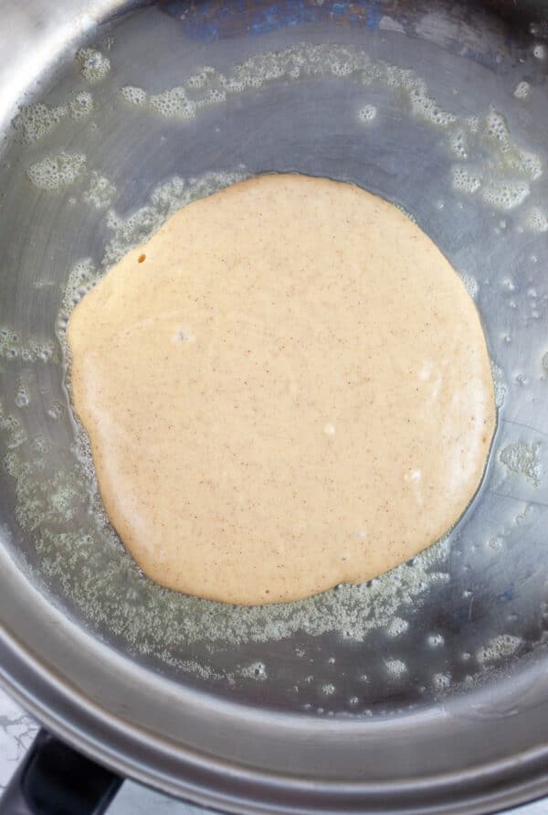 Uncooked pancake batter in skillet.