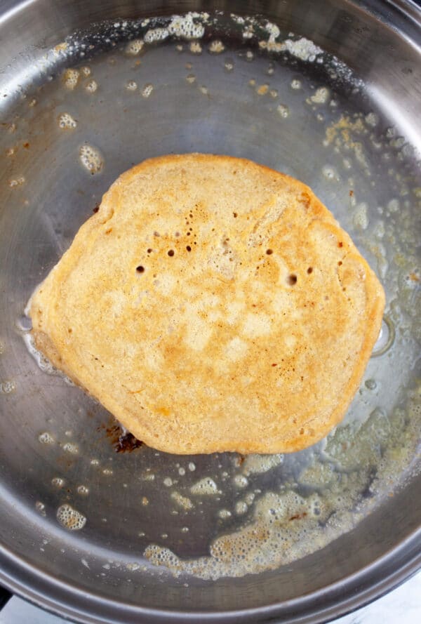 Cooked banana pancake in skillet.