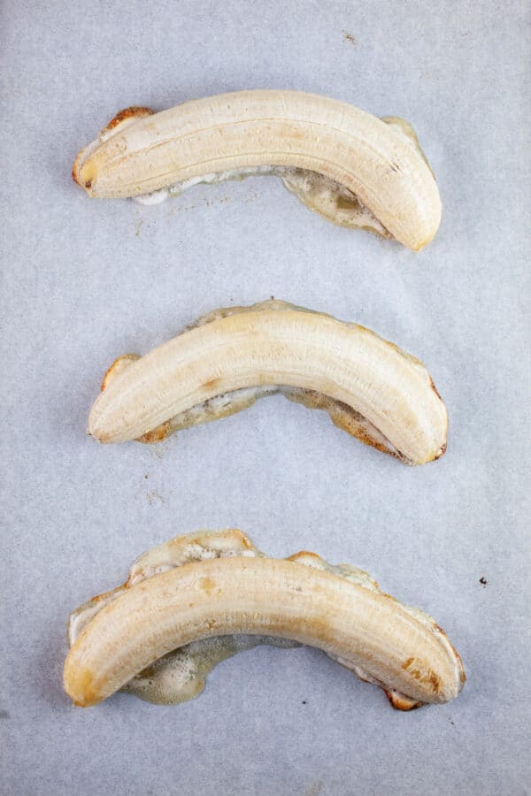 Roasted bananas on baking sheet lined with parchment paper.