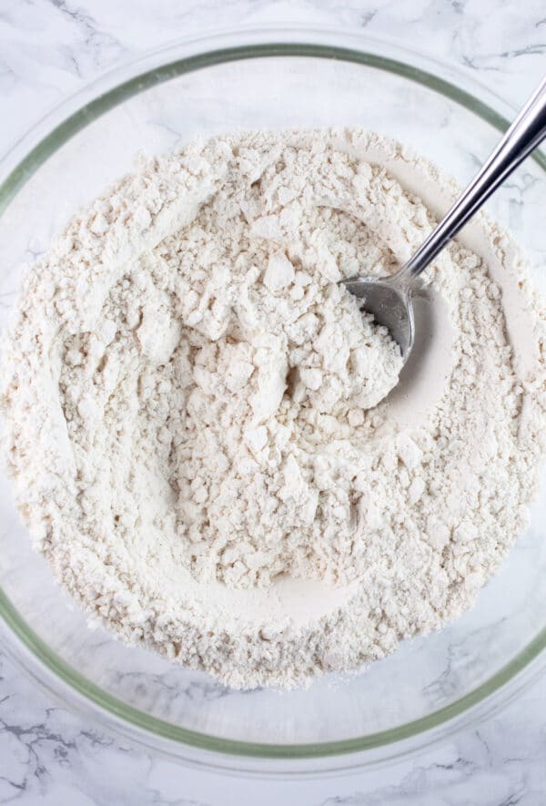 Dry ingredients combined in glass with with spoon.