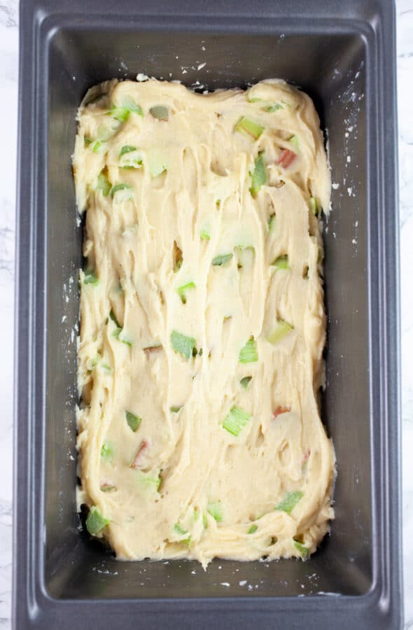 Half of rhubarb bread dough in metal bread pan.