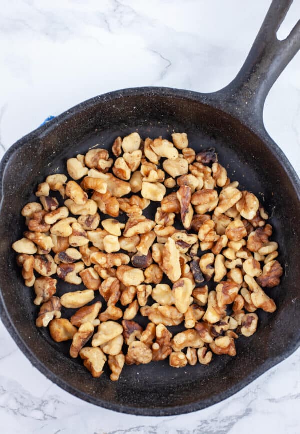 Toasted walnuts in small cast iron skillet.