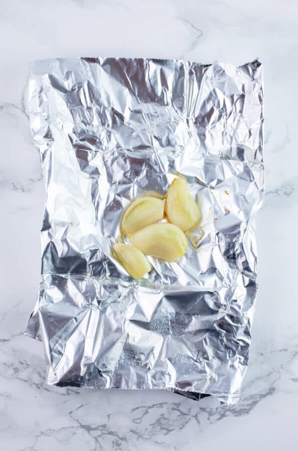 Roasted garlic on piece of tinfoil.