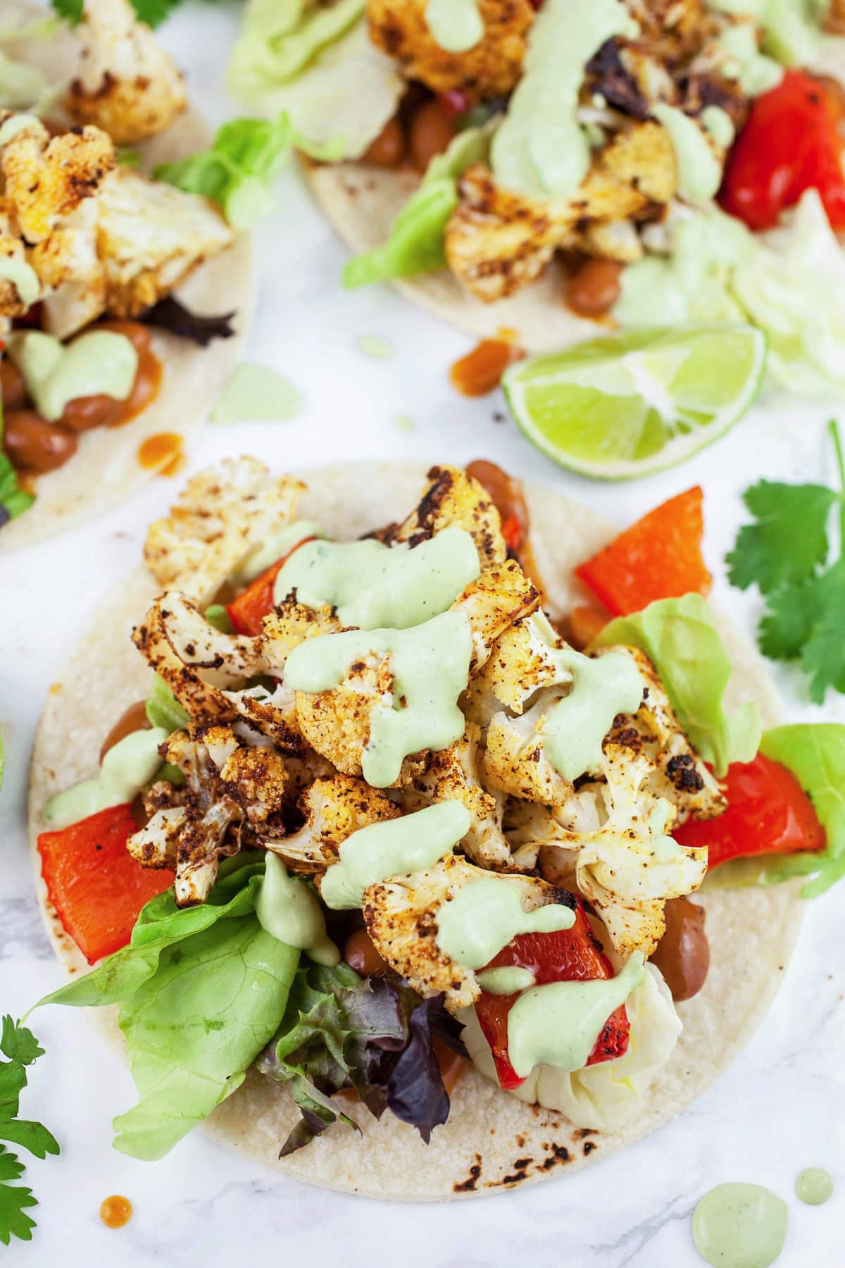 Roasted vegetable tacos topped with cashew cilantro sauce.