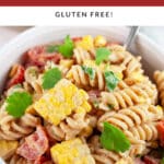 Southwest pasta salad garnished with cilantro in white bowl with fork.