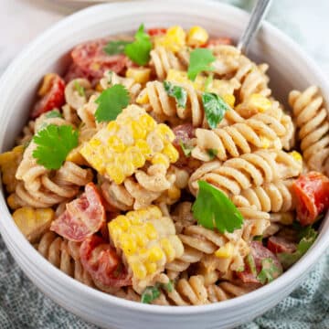 Southwest pasta salad garnished with cilantro in white bowl with fork.