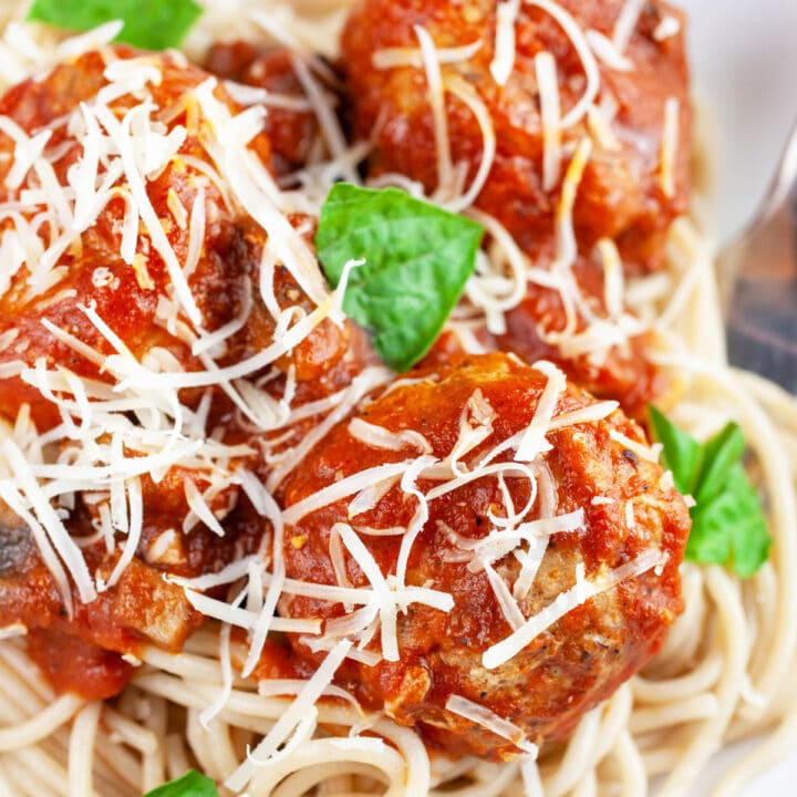 Spaghetti and turkey meatballs garnished with Parmesan cheese and fresh basil.