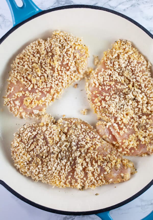 Breaded chicken breasts sauteed in cast iron skillet.